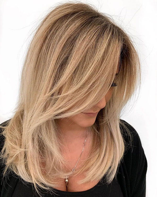Mid-Length Feathered Caramel Blonde Hairstyle